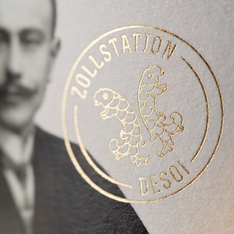 Detailaufnahme des Logos mit Goldfolierung auf dem Etikett der Weinlinie Zollstation